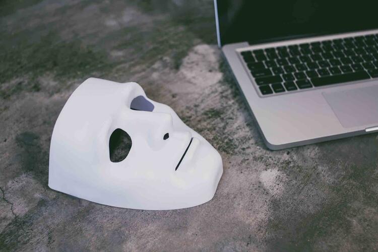 masque blanc posé à côté d'un ordinateur