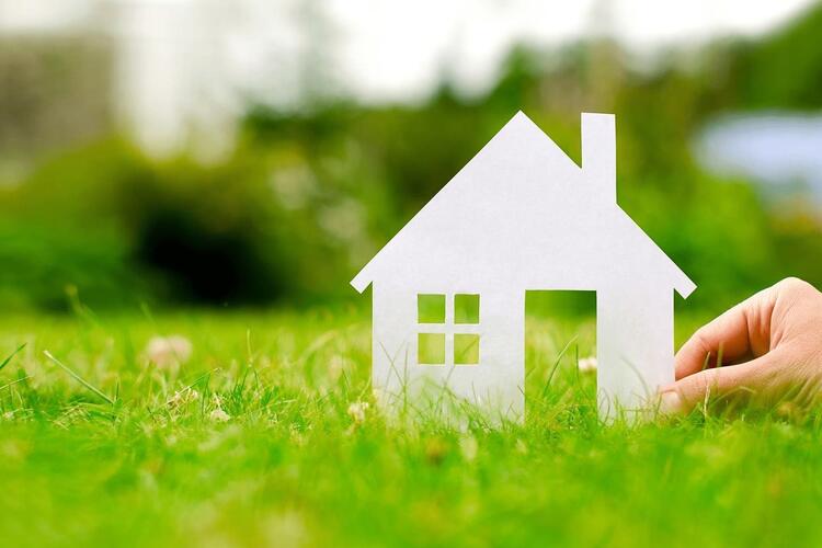 Maquette de maison posé sur une pelouse illustrant le Plan epargne logement