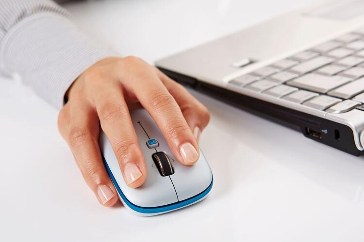 main d'un individu cliquant sur une souris d'ordinateur afin de représenter la résiliation en 3 clics en assurance