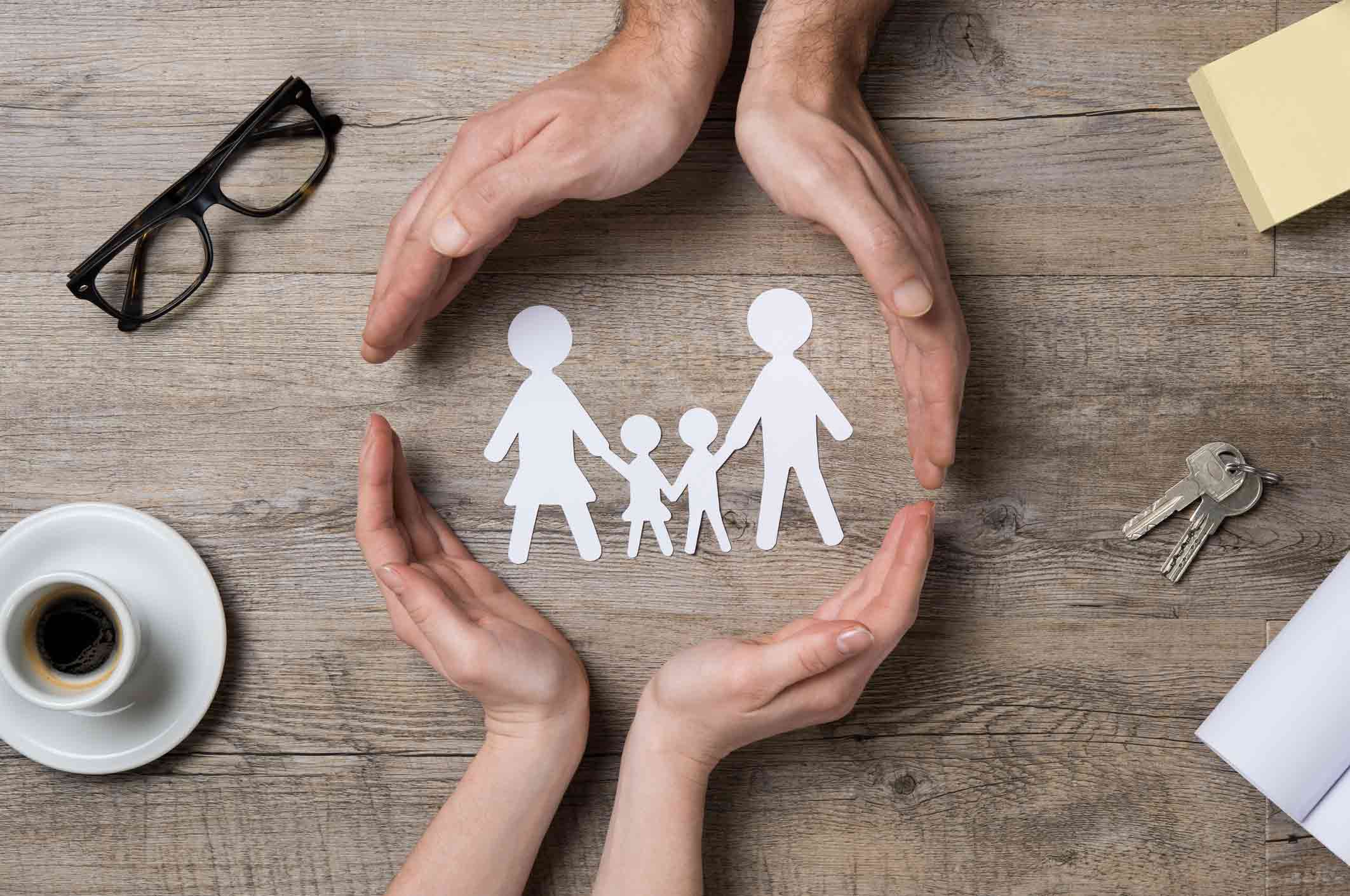 visuel d'une famille en papier entourée par des mains