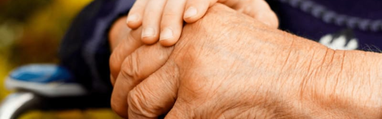 main d'un enfant tenant la main d'une personne âgée