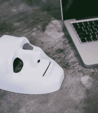 masque blanc posé à côté d'un ordinateur