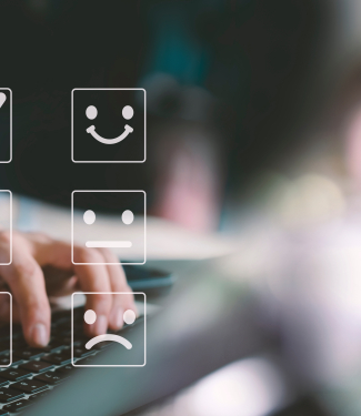 homme devant son ordinateur qui sélectionne le smiley content pour montrer sa satisfaction