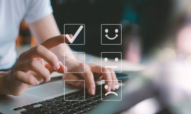 homme devant son ordinateur qui sélectionne le smiley content pour montrer sa satisfaction